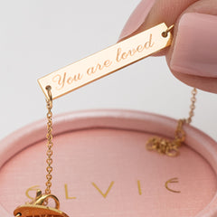 Gold engraved necklace engraved with the phrase "You are loved"