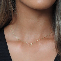 Petite letter necklace in gold on model