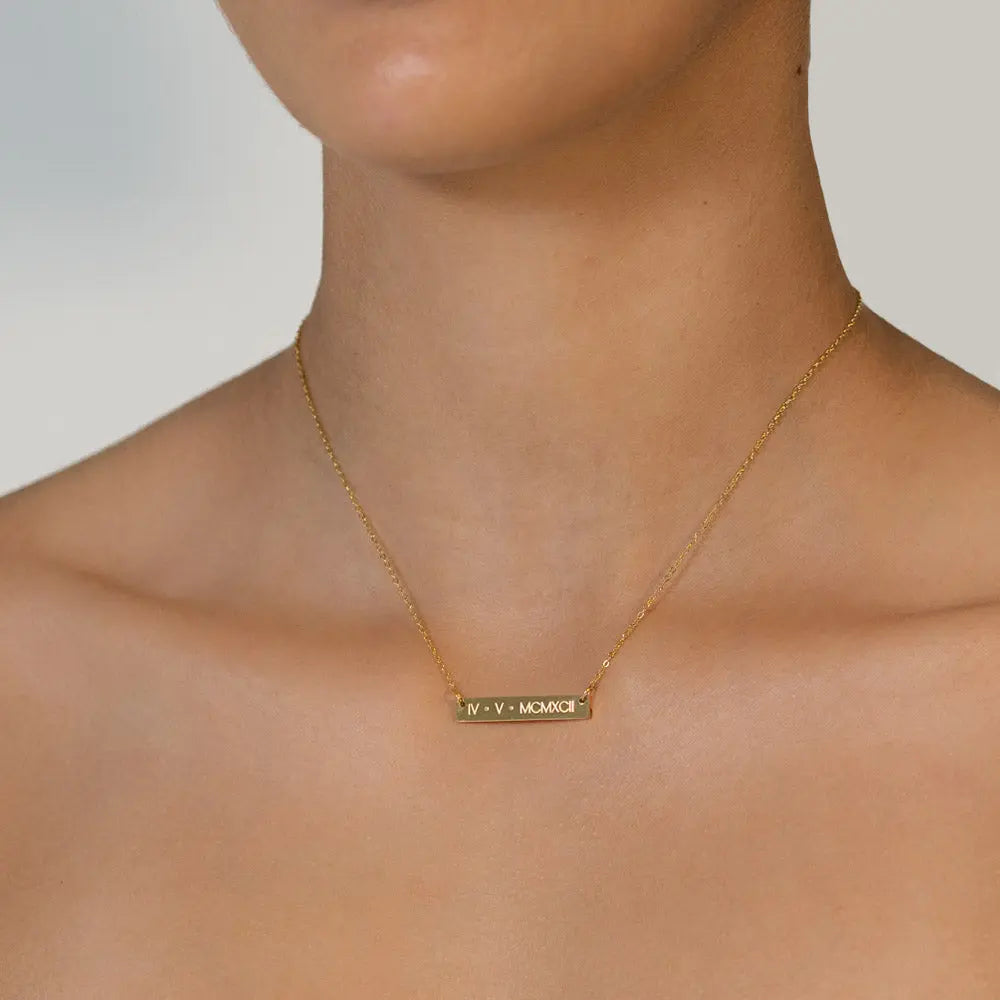 Gold Engraved Necklace with a date in roman numerals engraved on the front