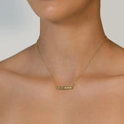 Gold Engraved Necklace with a date in roman numerals engraved on the front