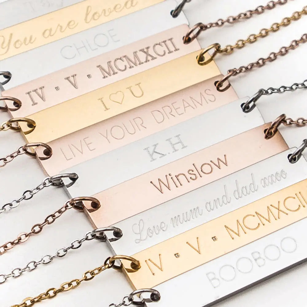 Examples of multiple engraved necklaces in gold and silver, engraved with names, words, dates, co-ordinates, and engraved in different font styles